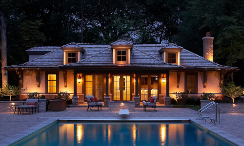 Backyard of house with a stone patio and path lights